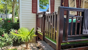 A small house with a wooden deck and a garden.