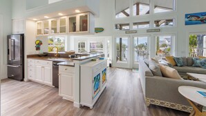 A spacious kitchen with a central island, white cabinetry, and a stainless steel refrigerator. - The Poop Deck: *Pet-friendly *Canalfront *Heated Pool *Sleeps 8 (Anna Maria)