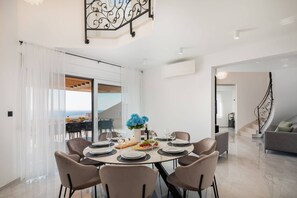 A modern dining area with a table set for six, a staircase, and a view to the outside. - Luxury Villa Leisure Seaside Brac with Pool (Milna)