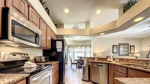 A modern kitchen with stainless steel appliances, wooden cabinets, and a granite countertop. - 4 Bed 4 Bath With Private Pool/spa 4 Bedroom Home by RedAwning (Davenport)