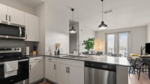 Una cocina moderna con electrodomésticos de acero inoxidable, una isla central con pileta y un comedor con vistas.