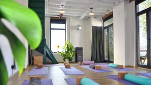 A yoga studio with multiple mats and foam rollers, wooden flooring, and large windows allowing natural light. - Zennon II - Feel Good (Geraardsbergen)