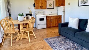 Un espace de vie compact comprenant un coin repas, une kitchenette et un canapé.