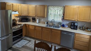 Una cocina moderna con armarios de madera, electrodomésticos de acero inoxidable y encimera de granito.