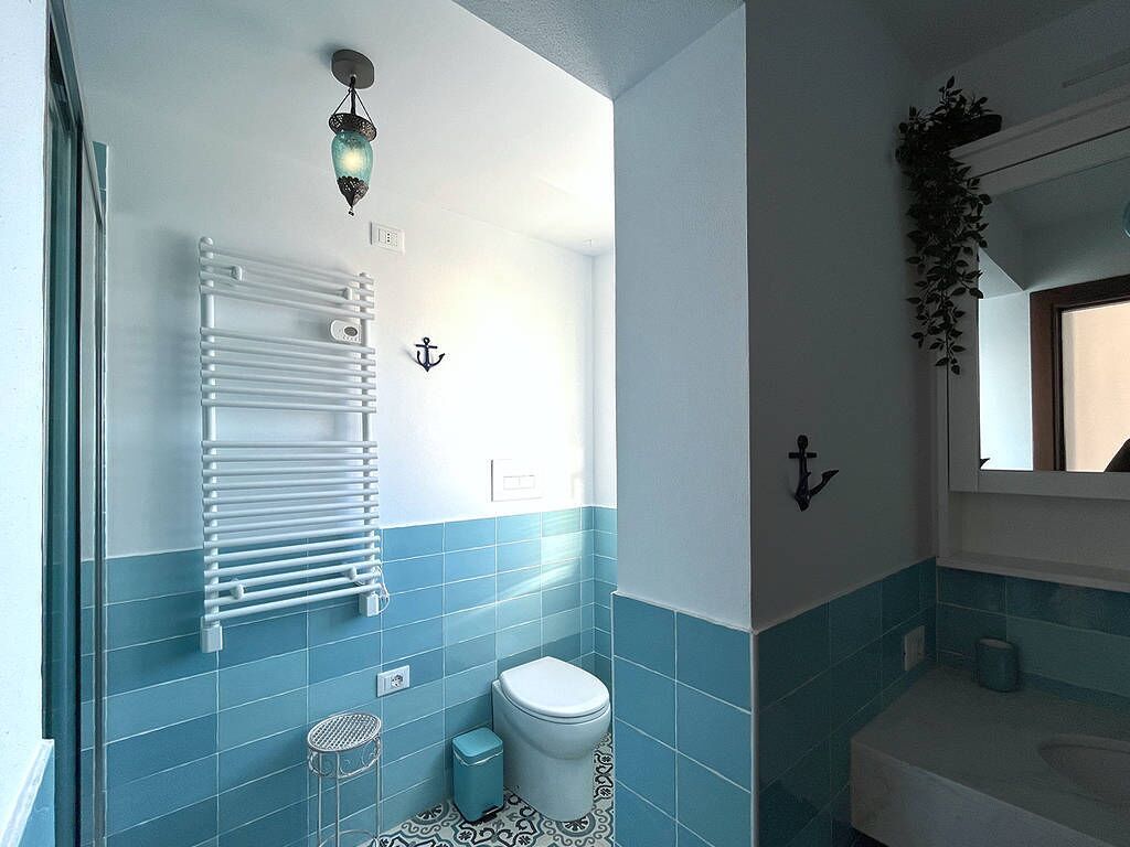 Ein Badezimmer mit Toilette, Waschbecken und Handtuchhalter.