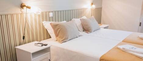 A hotel room with a bed, bedside tables, and a nightstand.