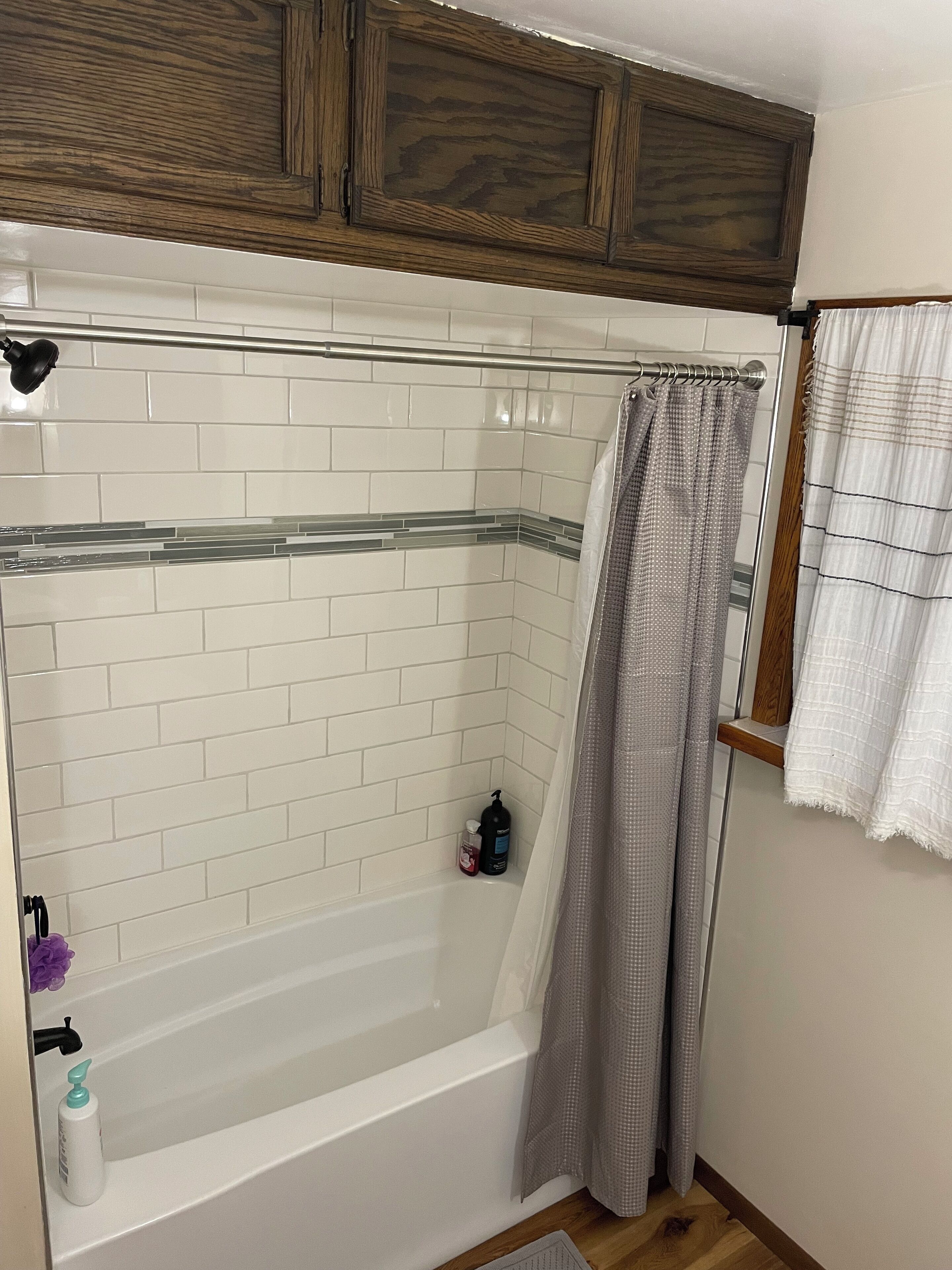 A bathroom with a bathtub, a shower curtain, and a towel rack.