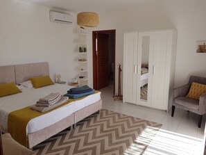 Cozy retreat with a large bed, wardrobe, and woven basket.