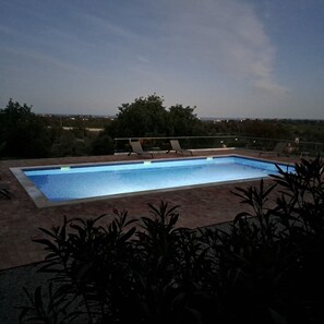 Relax by the pool surrounded by lush greenery and take in the breathtaking views of the distant landscape.