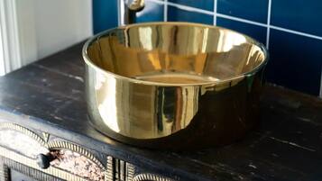 A shiny, empty brass bowl on a dark surface with intricate designs.