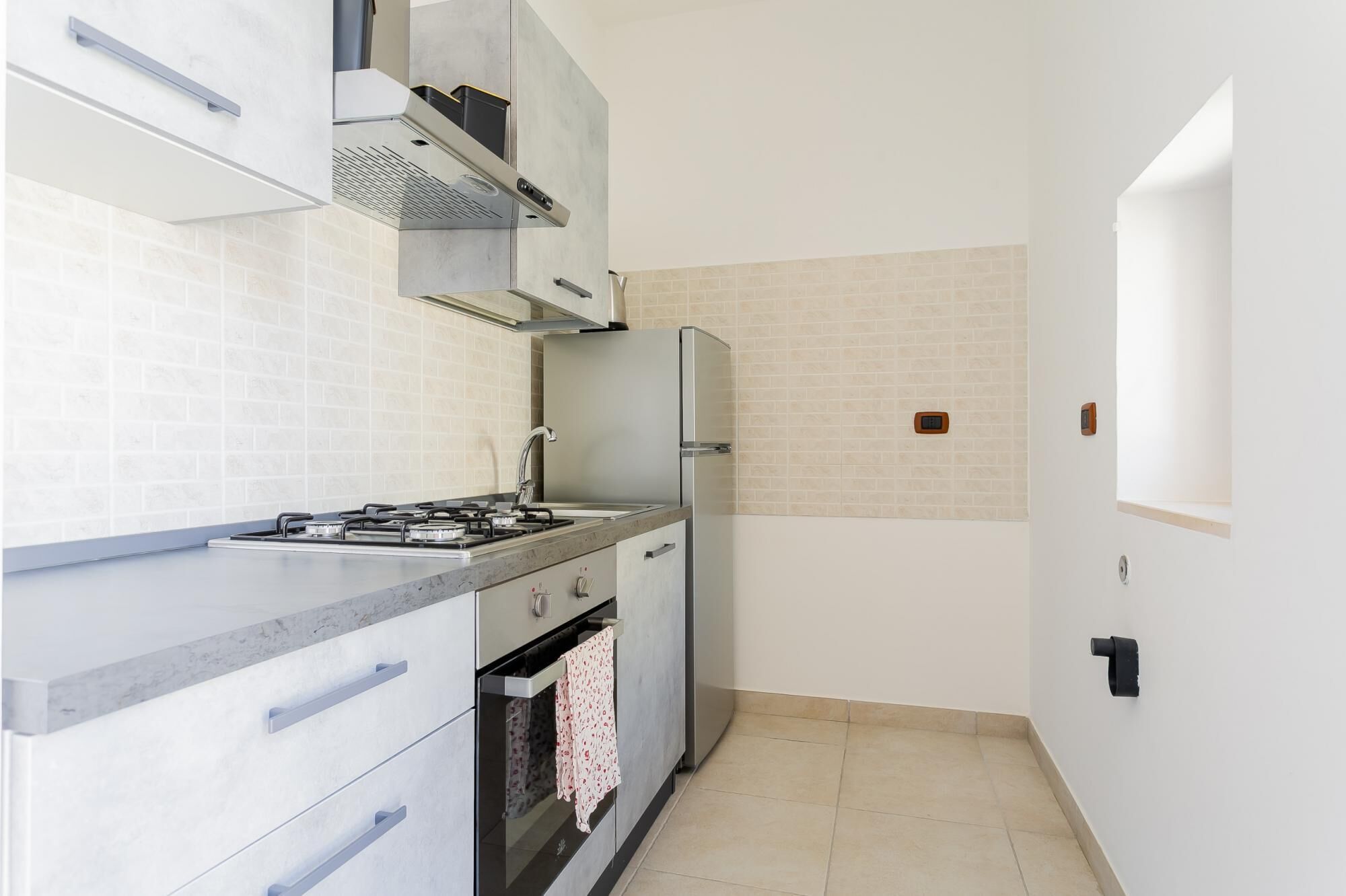 A compact kitchen with a gas stove, oven, and a refrigerator.
