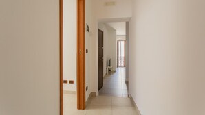 A narrow hallway with white walls and a wooden door frame. - Chez Isabella by Wonderful Italy (Noicattaro)