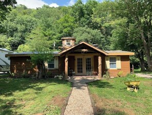 Escape to a serene forest retreat with a cozy porch and garden.