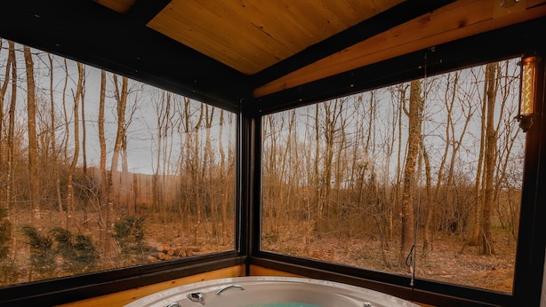 A hot tub in a wooden cabin with a view of a forest. - Pentalow Cabin (Kartepe)
