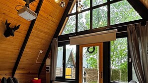 A cozy loft-style room with a large window, a wooden ceiling, and a modern sofa. - Pentalow Cabin (Kartepe)