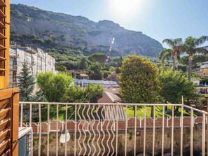 A balcony with a view of a mountainous landscape, a white fence, and a hanging light fixture. - Maison Rosa (Meta)