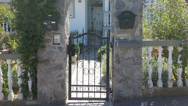 A stone archway with a metal gate leading to a building entrance.