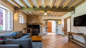 Una sala de estar acogedora con chimenea, un sofá y un televisor.