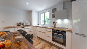 A modern kitchen with white cabinets, a wooden countertop, and stainless steel appliances.