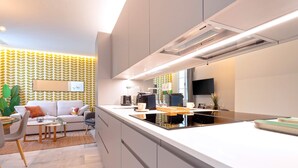 Une cuisine moderne dotée d’un îlot central, d’appareils électroménagers intégrés et d’un coin repas avec un canapé et une table basse.