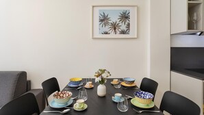 A dining area with a table set for four, surrounded by black chairs. A framed picture hangs on the wall above the table. - Riviera Flavour Apartments by Wonderful Italy - Valeriana (Santa Margherita Ligure)