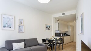 A compact living space with a sofa, dining table, and kitchen area. - Riviera Flavour Apartments by Wonderful Italy - Valeriana (Santa Margherita Ligure)
