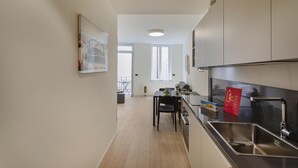 A narrow kitchen with a dining area, a window, and a view of the outside balcony. - Riviera Flavour Apartments by Wonderful Italy - Valeriana (Santa Margherita Ligure)