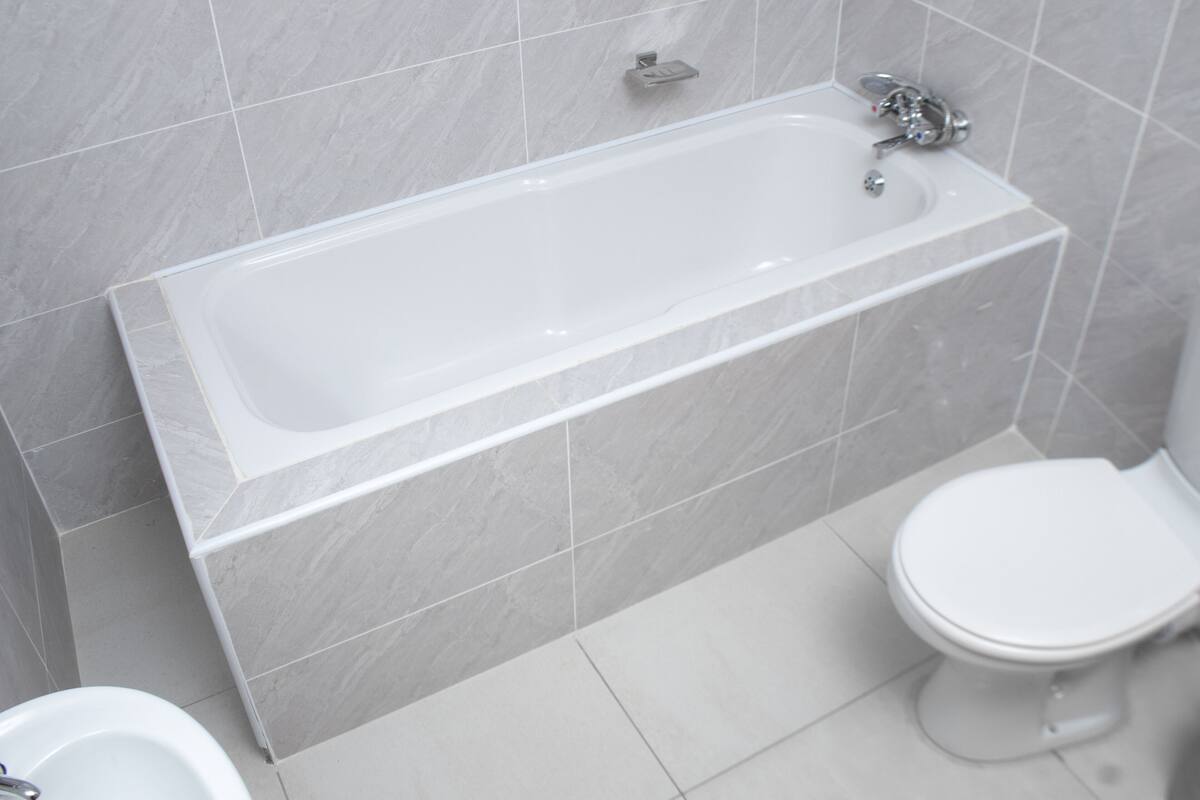 Ein Badezimmer mit Badewanne, Toilette und Duschbereich.