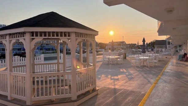 A gazebo with a roof and railings, surrounded by tables and chairs on a deck. - Sunny Wildwood Crest condo! Perfect spot, 1 block to beach ☀️🌊 (Wildwood)
