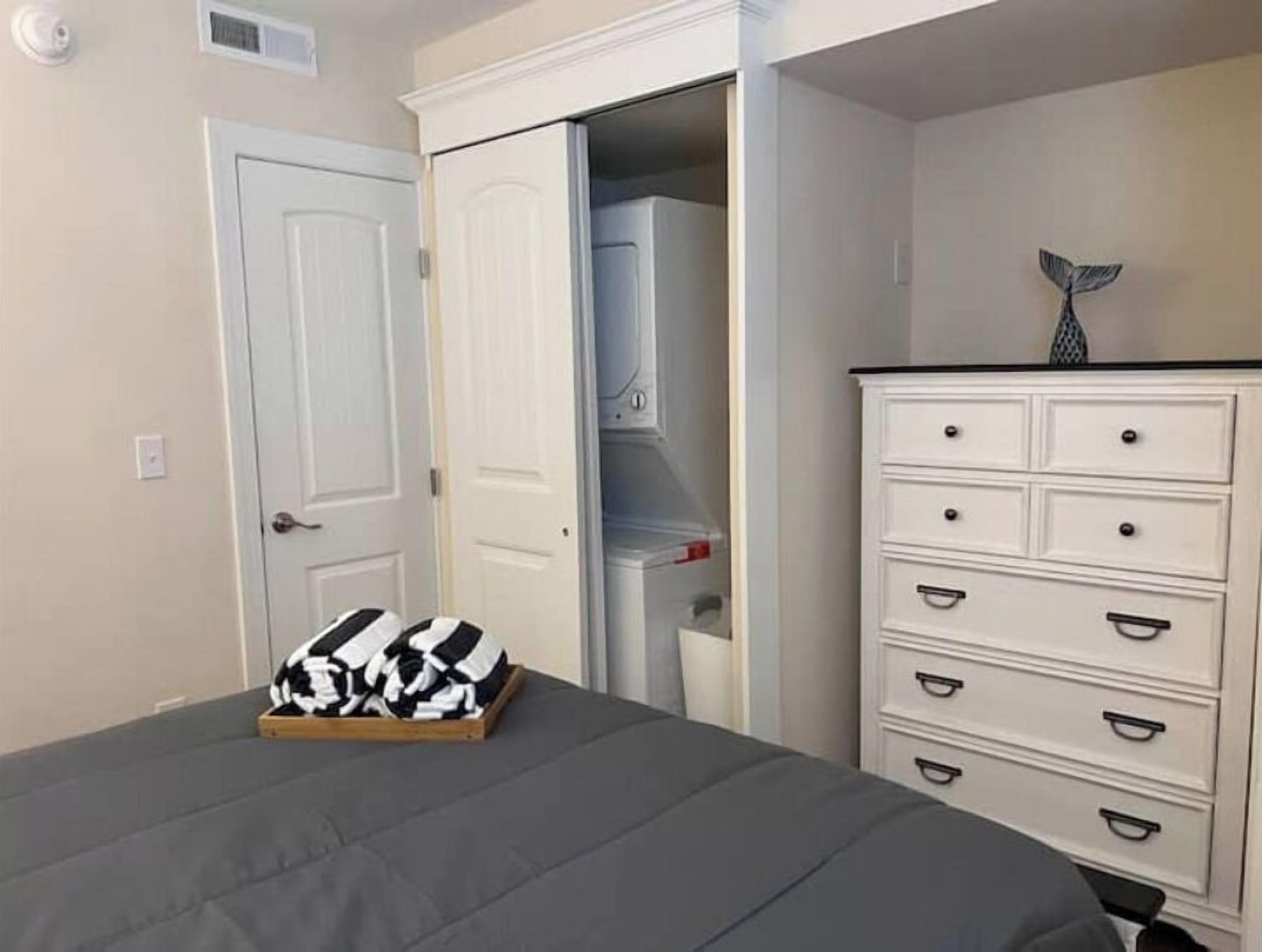 Un dormitorio con cama, cómoda y armario.