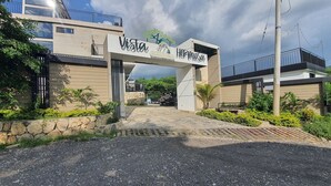 A modern building entrance with a sign reading "Vista Hermosa." - Romantic glamping at Vista Hermosa, enjoy nature in a private and cozy environment. (San joaquin-La Mesa)