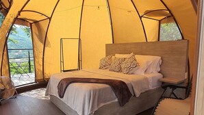 A tented room with a bed, a fan, and a view of greenery outside. - Romantic glamping at Vista Hermosa, enjoy nature in a private and cozy environment. (San joaquin-La Mesa)