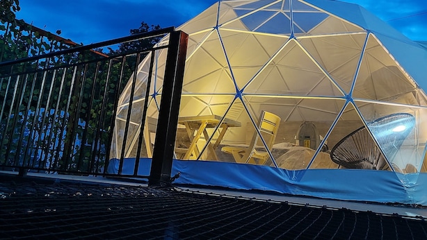 A geodesic dome structure with a grid-like interior, surrounded by a metal fence and covered with a tarp. - Romantic glamping at Vista Hermosa, enjoy nature in a private and cozy environment. (San joaquin-La Mesa)