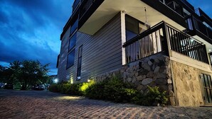 Un edificio moderno de dos pisos con fachada de piedra y un balcón.