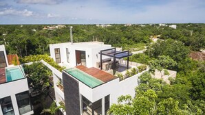 A modern building with a rooftop pool and a covered outdoor seating area. - Royal PH Private Rooftop Deck Pool (Tulum)
