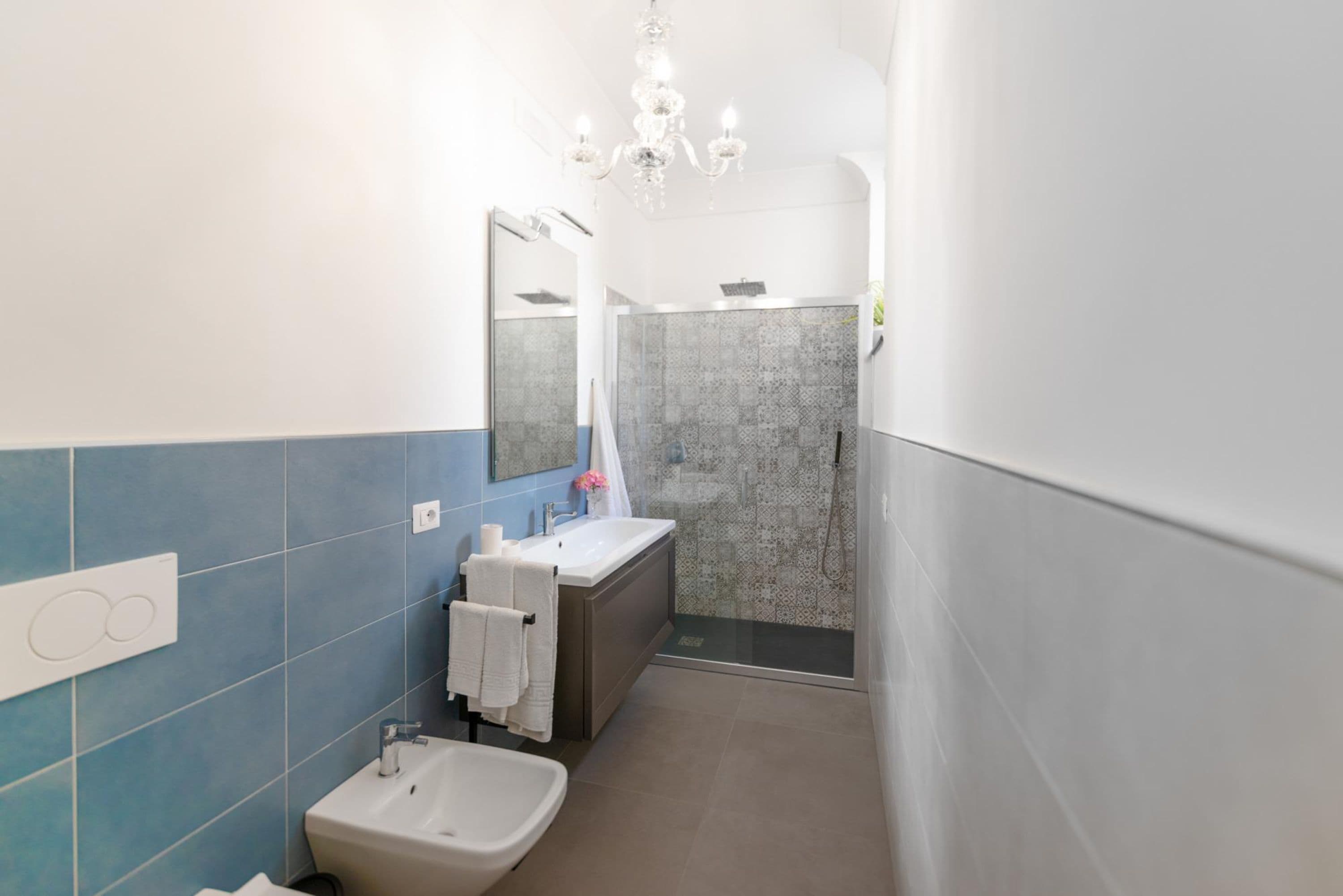 A modern bathroom with a sink, vanity, and shower.