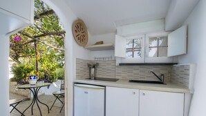 A compact kitchen with a sink, white cabinets, and a small refrigerator. - Villa Albatros - Stunning 2 Floors Villa for Large Groups (Praiano)