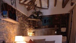 Una sala de estar acogedora con un sofá modular, una mesa de centro y una pared de piedra.