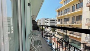 Un balcon donnant sur les immeubles voisins et sur la rue en contrebas.