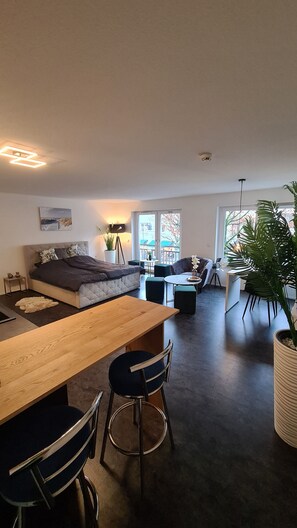 Relax in a spacious living area with a sofa, dining table, and large window offering a view of the outdoors.
