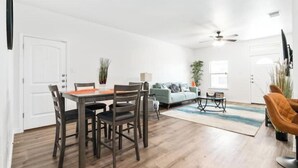Ein geräumiges Wohnzimmer mit Essbereich, einer Couch und einem Deckenventilator.