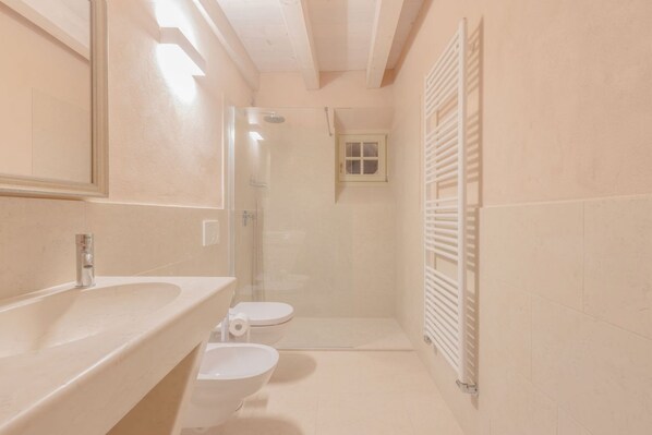Un baño pequeño con lavamanos, inodoro y ducha.