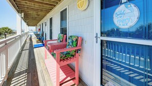A wooden deck with pink chairs and a blue door with a sign reading "The Beach is my Happy Place". - Walk to Beach & Pier: Quiet Retreat in Surf City (Surf City)