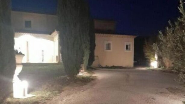 Una strada sterrata conduce a un edificio con un piccolo portico e un'unica finestra.