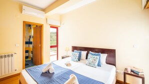 A hotel room with a bed, a bedside table, a lamp, and a view through the door. - Modern villa with a welcoming atmosphere (Albufeira)