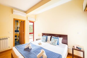 Ein Hotelzimmer mit Bett, Nachttisch, Lampe und Blick durch die Tür.