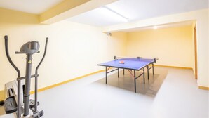 A room with a ping pong table, exercise equipment, and a ceiling light. - Modern villa with a welcoming atmosphere (Albufeira)