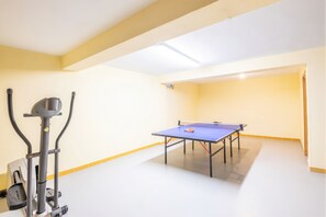 A room with a ping pong table, exercise equipment, and a ceiling light. - Modern villa with a welcoming atmosphere (Albufeira)