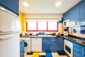 A compact kitchen with a washing machine, a microwave, and a toaster. - Modern villa with a welcoming atmosphere (Albufeira)