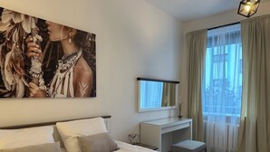 Une chambre moderne avec un grand lit, un bureau et une fenêtre avec des rideaux.